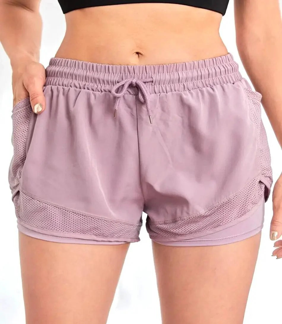 Shorts Fitness Feminino preto com bolsos invisíveis, cintura alta e tecido de secagem rápida, ideal para treinos e conforto diário.